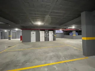 Imagem de um espaço interno amplo e vazio com piso de concreto.