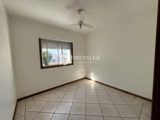 Ambiente interno com piso de cerâmica e janela na parede.