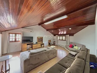 Foto da sala de estar com teto de madeira no imóvel.