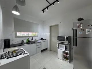 Foto de uma cozinha com armários brancos e piso de cerâmica.
