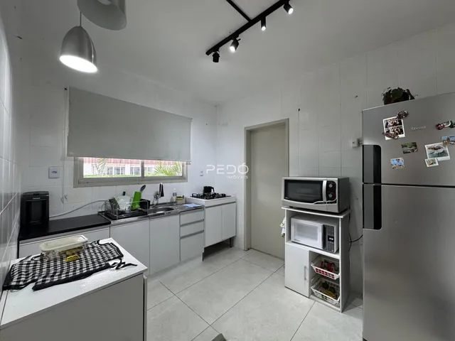 Foto de uma cozinha com armários brancos e piso de cerâmica.