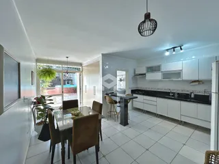 Vista de uma sala de jantar integrada com cozinha em um imóvel no Brasil.