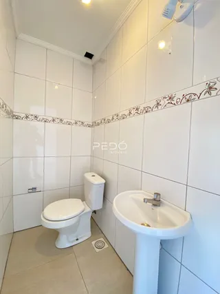 Foto de um banheiro com revestimento de azulejos brancos.