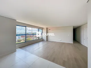 Sala ampla com grande janela oferecendo vista da paisagem urbana.