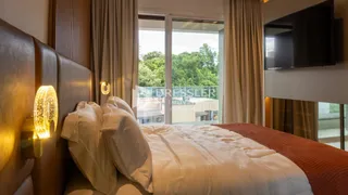 Quarto com cama e cortinas em um imóvel.