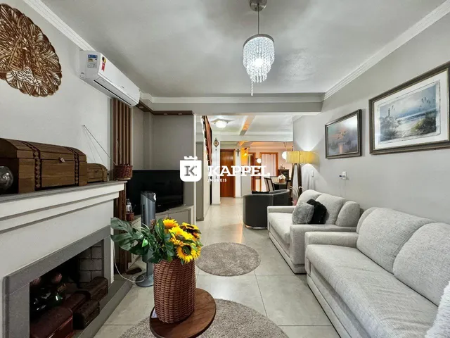 Sala de estar com lareira e sofá de cor clara em um apartamento.