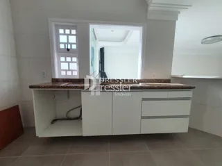 Vista da cozinha com bancada e janela em uma residência.