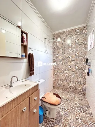 Banheiro com revestimento de azulejos no chão e parede.
