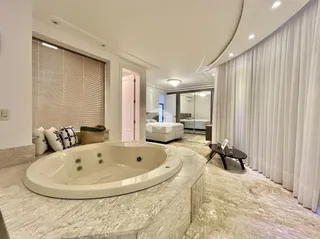 Banho oval em um ambiente de luxo com piso de mármore.