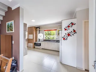 Cozinha com armários e bancada clara em um apartamento.