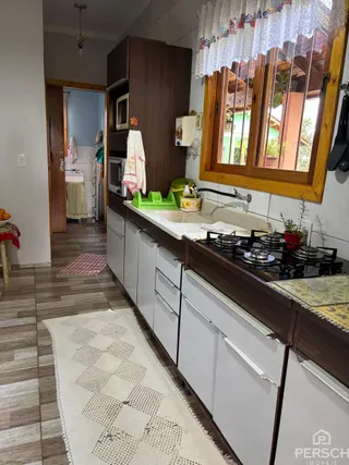 Foto de uma cozinha com armários de madeira escura e bancada.