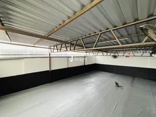 Imagem de um espaço interno com teto de estrutura metálica exposta.