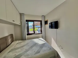 Quarto com janela e armário branco na residência.