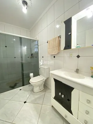 Foto de um banheiro com piso de cerâmica branca.