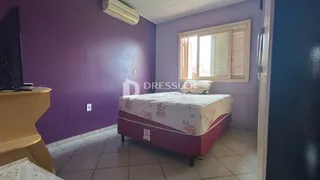Quarto com cama e janela em ambiente com paredes roxas.