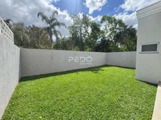 Vista de um gramado verde cercado por paredes brancas