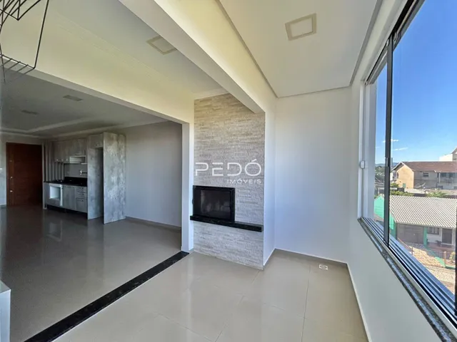 Sala de estar com piso claro e parede de destaque em imóvel no Lajeado.