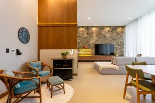 Sala de estar moderna com piso de madeira e parede de pedra.
