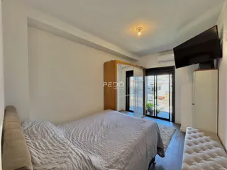 Quarto com cama e armários de madeira em um apartamento.