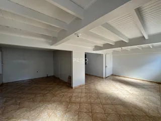 Ambiente interno com piso de cerâmica e forro de madeira no imóvel.
