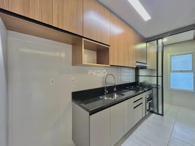 Cozinha moderna com armários de madeira e bancadas escuras.