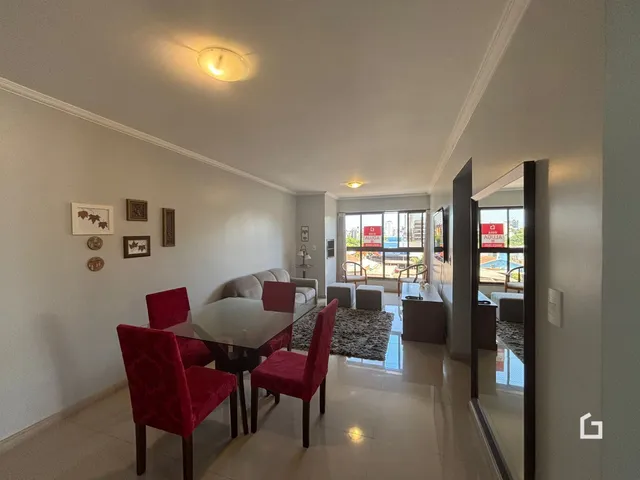 Sala de estar com mesa de jantar e espelho refletindo o ambiente.