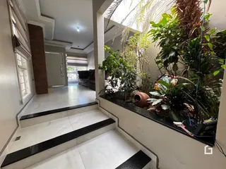 Hall de entrada com piso de porcelanato e área verde decorativa.