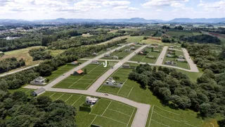 Vista aérea de um loteamento rural com terrenos e vegetação no Brasil.
