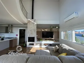 Sala de estar com vista para o exterior e cozinha integrada.