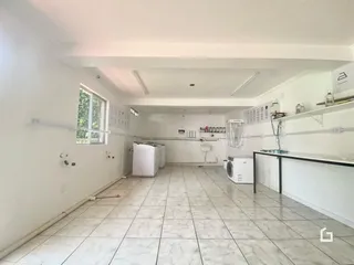 Interior de uma sala com piso de cerâmica e eletrodomésticos visíveis.