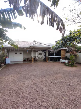 Fachada de uma residência em Lajeado, Brasil, com área externa de cascalho.