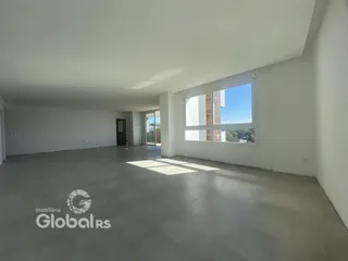 Uma sala ampla com paredes brancas e piso de concreto.