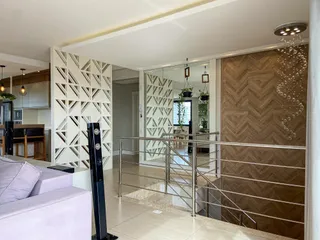 Sala de estar com decoração moderna e escadaria em um apartamento em Lajeado.