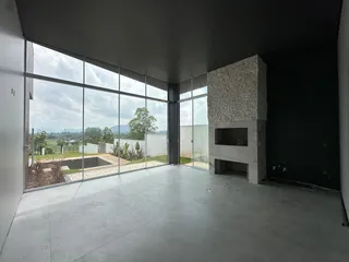 Sala ampla com grandes janelas que oferecem vista para a paisagem externa.