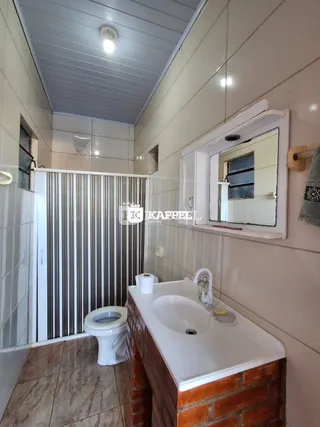 Foto de um banheiro com azulejos brancos e um lavatório.