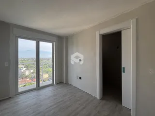 Sala com grandes janelas que oferecem uma vista da cidade.