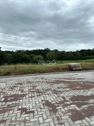 Vista externa de uma propriedade com paisagem de campo e vegetação ao fundo.