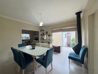 Uma sala de jantar com mesa e cadeiras azuis em um imóvel no Brasil.