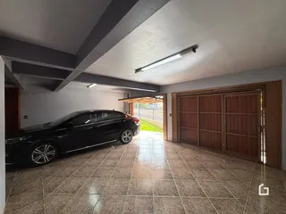 Foto de uma área interna com piso de cerâmica e porta de madeira.