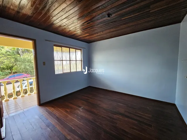 Vista interna de uma sala com piso e teto de madeira.