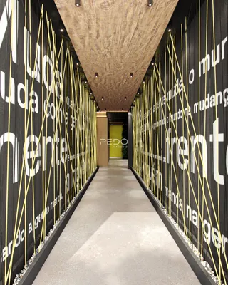Corredor interno de um imóvel com design moderno e paredes decoradas.
