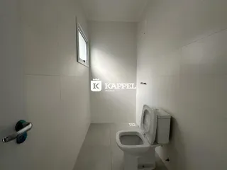 Este é um banheiro com paredes brancas e um vaso sanitário branco.