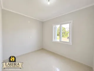 Sala de estar com paredes brancas e piso de cerâmica.