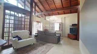 Sala de estar com sofá e piso claro em ambiente com forro de madeira.
