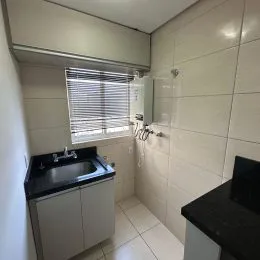 Foto de um ambiente interno com azulejos brancos e uma bancada.