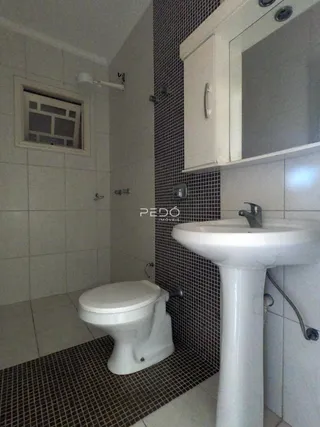 Foto interna de um banheiro com revestimento cerâmico e vaso sanitário branco.