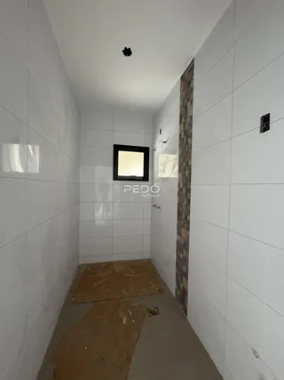 Corredor interno com paredes brancas e uma coluna de destaque.