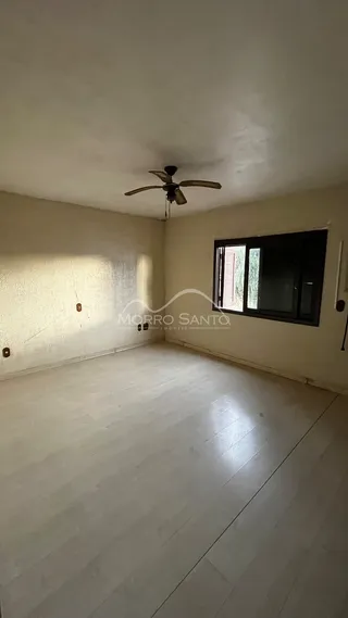 Sala de estar com piso de madeira clara e janela.