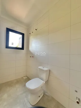 Foto de um banheiro com paredes brancas e piso claro.
