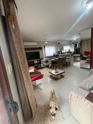 Interior de uma sala de estar com piso de cerâmica e sofá.